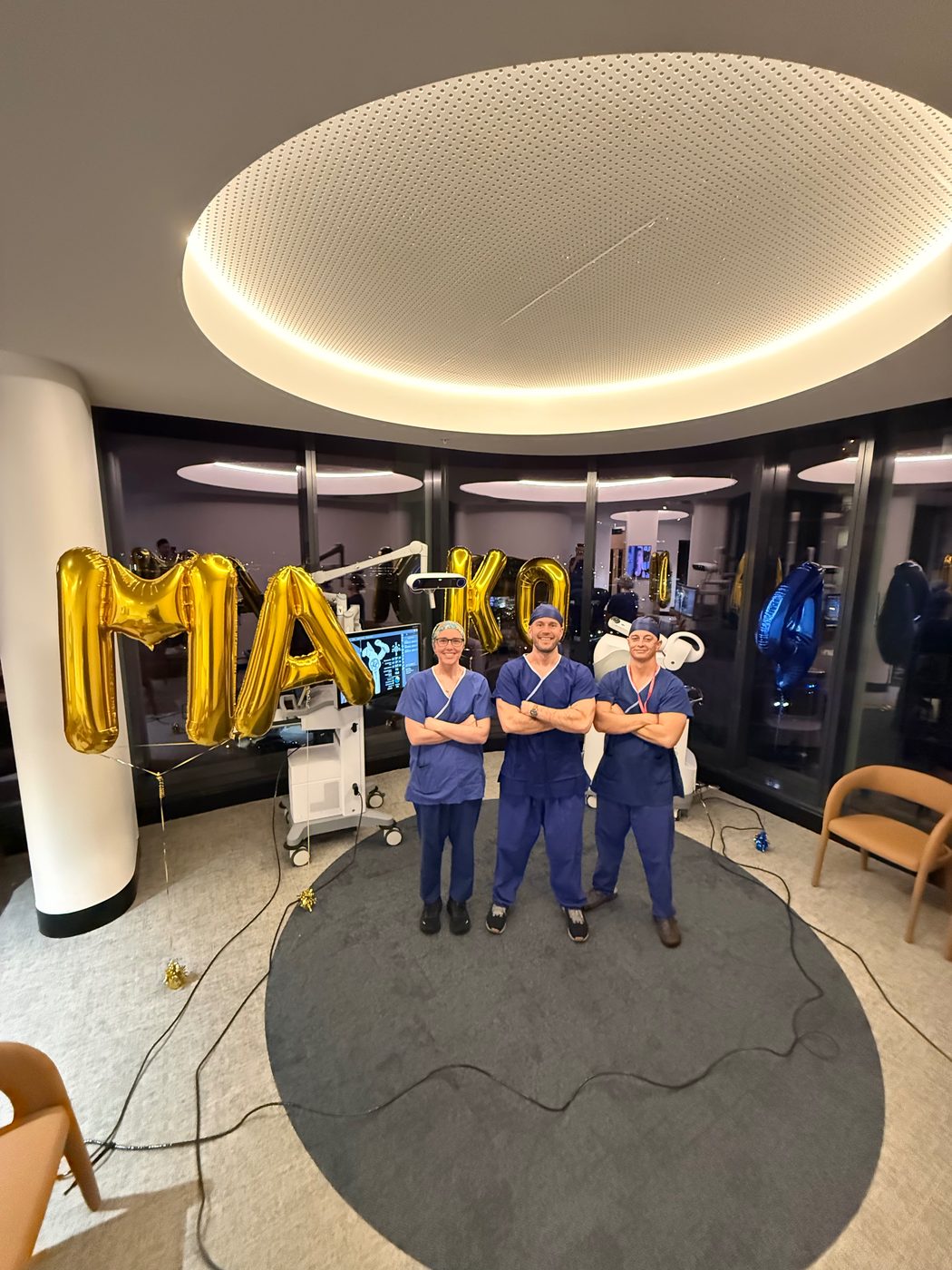 Dr Joe Coory with two members of the theatre team beside the Mako 4 robotic arm at Maroochy Private Hospital, 1 October 2026